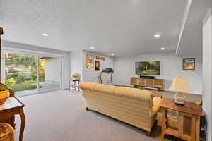 Living area featuring recessed lighting, a textured ceiling, and carpet floors