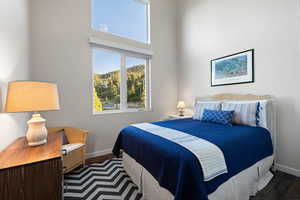Bedroom with wood finished floors and baseboards