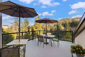 View of patio / terrace featuring outdoor dining space, a mountain view, and a forest view