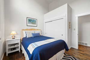 Bedroom featuring dark wood-type flooring and a closet