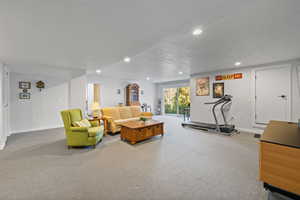 Carpeted living area with a textured ceiling and recessed lighting