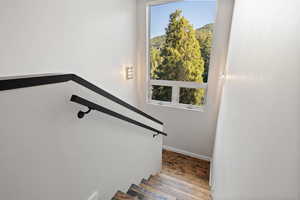 Staircase featuring baseboards and wood finished floors