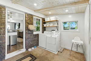 Washroom with washer and dryer, plenty of natural light, brick wall, wooden ceiling, and recessed lighting