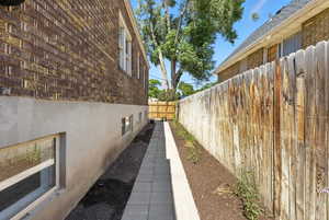 View of side of property featuring brick siding, stucco siding, and roof with shingles