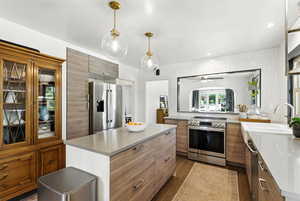 Kitchen with stainless steel appliances, modern cabinets, brown cabinets, and dark wood-type flooring