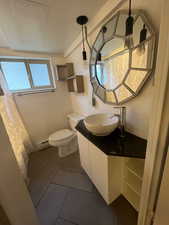 Full bathroom with a baseboard radiator, vanity, and tile patterned floors
