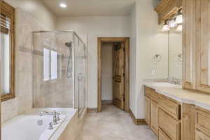 Full bathroom with vanity, a stall shower, a garden tub, tile patterned floors, and recessed lighting