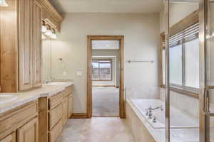 Full bathroom with double vanity, a bath, and tile patterned floors