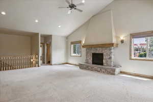 Unfurnished living room with high vaulted ceiling, plenty of natural light, carpet floors, ceiling fan, and recessed lighting