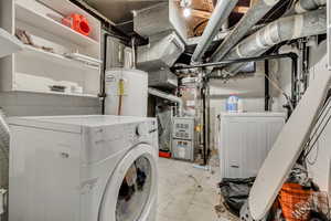 Unfinished basement with electric water heater, heating unit, and washer and clothes dryer