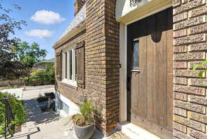 View of exterior entry with brick siding and a chimney