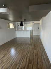 Unfurnished living room featuring dark wood finished floors and baseboards