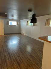 Unfurnished room featuring dark wood-style floors and a baseboard radiator