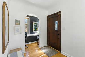 Entryway featuring light wood-style flooring and arched walkways