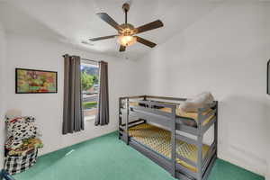 Carpeted bedroom featuring baseboards and ceiling fan