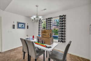 Dining space with a chandelier and baseboards