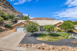 View of front of home featuring an attached garage, a tile roof, stucco siding, driveway, and a front lawn