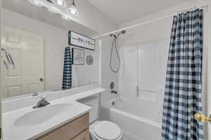 Bathroom featuring shower / bath combo with shower curtain and vanity