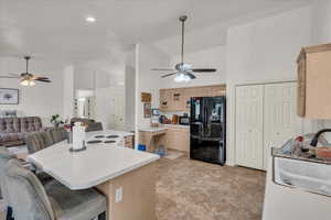 Kitchen with freestanding refrigerator, ceiling fan, light brown cabinetry, high vaulted ceiling, and recessed lighting