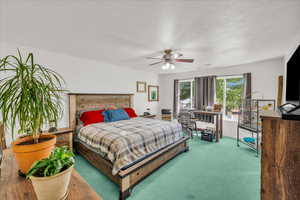 Bedroom featuring carpet floors, ceiling fan, and a textured ceiling