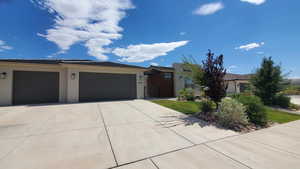 View of front of house featuring extra wide 3 car garage  and landscaping Summer 2025