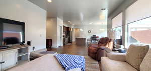 Living room featuring wood finished floors, a chandelier, and recessed lighting