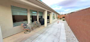 Fenced backyard featuring grilling area and a patio