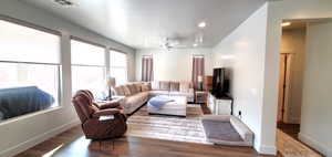 Living area featuring wood finished floors, a ceiling fan, and recessed lighting