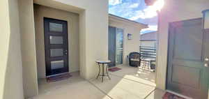 Entrance to property with stucco siding and a balcony