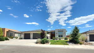 Modern home featuring stucco siding, a garage, concrete driveway, and roof mounted solar panels