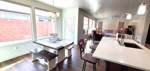 Dining area with dark wood-style flooring, a chandelier, and ceiling fan