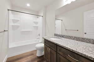 Bathroom featuring wood finished floors, vanity, bathtub / shower combination, and recessed lighting