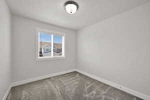Unfurnished room with dark carpet and a textured ceiling