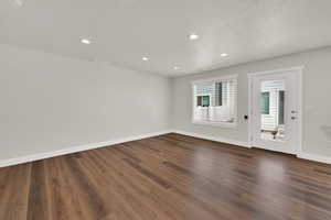 Unfurnished room with dark wood-style flooring, recessed lighting, and a textured ceiling