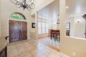 Entryway with a chandelier, light tile patterned floors, and recessed lighting