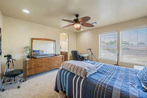Carpeted bedroom with arched walkways, recessed lighting, ceiling fan, and connected bathroom