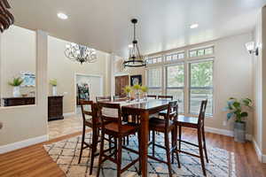 Dining space with a chandelier, light wood-style floors, and recessed lighting