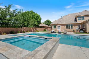 View of swimming pool with an in-ground hot tub, a patio area, a fenced backyard, and area for grilling