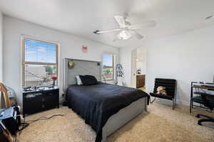 Bedroom featuring light colored carpet, arched walkways, ceiling fan, and ensuite bathroom