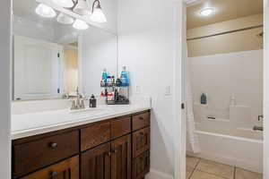 Full bath with vanity, shower / bath combination with curtain, and tile patterned floors