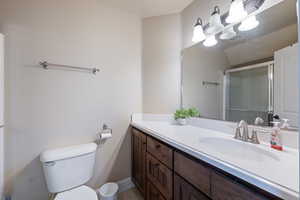 Bathroom with vanity and a shower with door