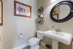 Half bathroom with toilet and tile patterned floors