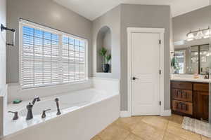 Full bath with vanity, a garden tub, and tile patterned floors