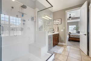 Bathroom with a stall shower, vanity, connected bathroom, and a ceiling fan