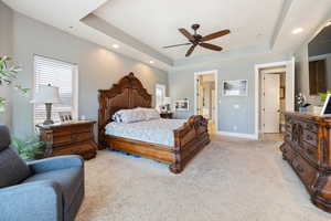 Bedroom featuring light colored carpet, a tray ceiling, recessed lighting, and ceiling fan