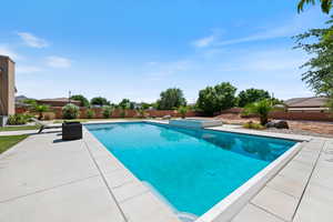View of pool featuring a patio area, a fenced backyard, and a pool with connected hot tub