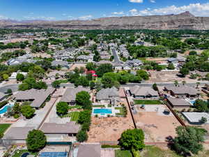 Aerial perspective of suburban area featuring a pool area and a mountainous background
