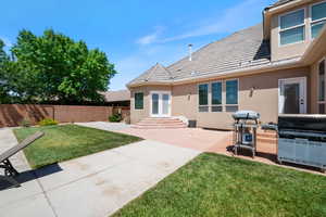 Rear view of property with stucco siding, a patio area, and french doors