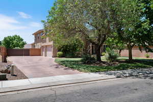 Obstructed view of property featuring driveway, stucco siding, a garage, and a gate