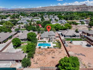 Aerial perspective of suburban area featuring a mountain backdrop and a pool